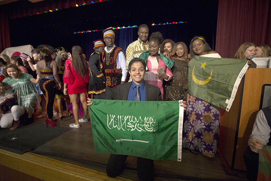 An international student holds a flag from Saudi Arabia.